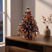 Dark beaded seasonal tree with orange pumpkin-shaped decorations