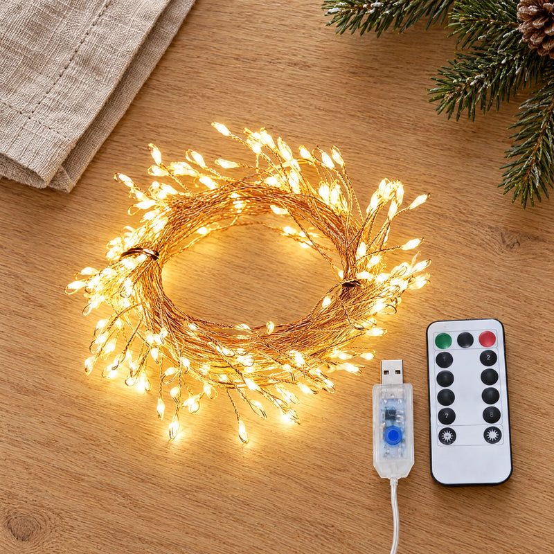 Copper wire light string, remote and controller laid flat on a light oak table