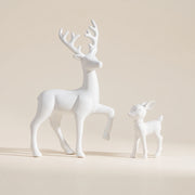 White deer and fawn figurines on a warm neutral background