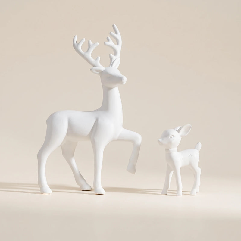 White deer and fawn figurines on a warm neutral background