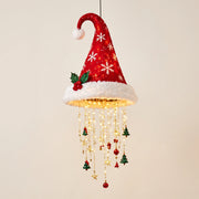 Snowflake Santa hat hanging light with warm LED strands against a cream wall.