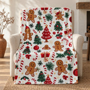 Gingerbread print Christmas throw blanket on a white ground, draped over a linen armchair