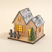 Style A wooden LED Christmas village house with snowy roof, tree and fence on a pale cream background