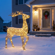 Glowing gold deer on a snowy front lawn at dusk