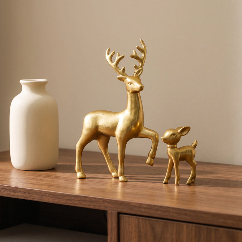 Golden deer and fawn figurines on a walnut console