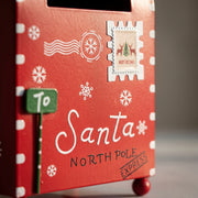 Close-up of the white printed motifs and lettering on the red Christmas mailbox