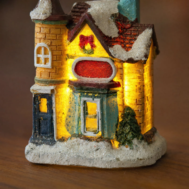 Close-up of textured painted resin facade and snowy base on Christmas village house