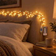 Copper wire light string lit along a linen headboard in a bedroom at night
