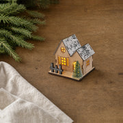 Style A wooden LED Christmas village house on a wood tabletop with fir branches and cream linen
