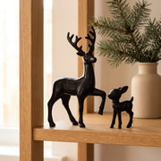 Black deer and fawn figurines on a light oak shelf