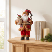 Plaid Santa figurine on a light oak mantel next to books and a candle
