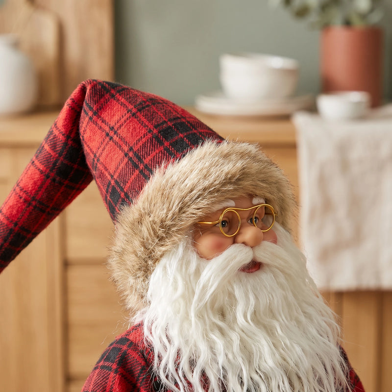 Close-up of the Santa's glasses, white beard and plaid hat with faux-fur brim