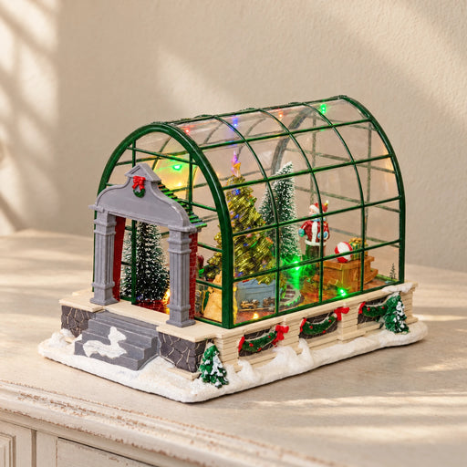 Musical LED Christmas greenhouse miniature on a pale cream console
