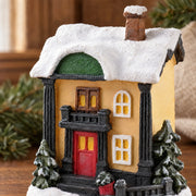 Close-up of the textured snow-effect roof and painted resin facade of a Christmas village miniature
