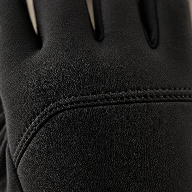 Macro close-up of the matte softshell and the seam across the back of the black glove