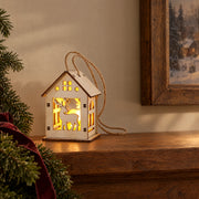 S9 reindeer Christmas house ornament glowing on a wooden console in the evening